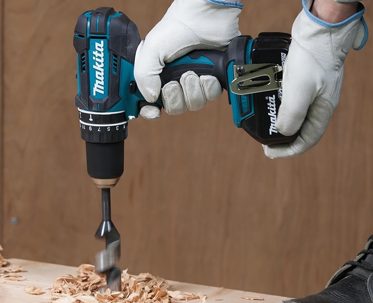 Makita DHP482RFX9 Akku-Schlagbohrschrauber beim Bohren in Holz mit Flachfräsbohrer